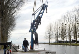 Les navigateurs, aidés d’un professionnel, remettent en place leur grue, utilisée pour sortir et mettre les bateaux à l’eau. © Michel Duperrex