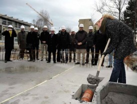 La municipale Marianne Savary, présidente de la Fondation yverdonnoise pour le logement, «enterre» dans le radier une boîte contenant les plans du bâtiment, les statuts de la Fondation et les quotidiens du jour. © Nadine Jacquet