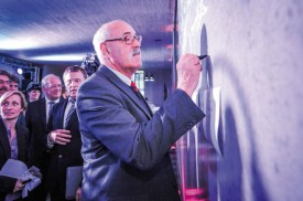 Le syndic de Sainte-Croix, Franklin Thévenaz, écrit son nom sur le mur de la future usine Reuge. © Bobby C. Alkabes