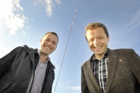 José Basset (à g.) et Thierry Salzmann, municipal à Bavois, au pied du mât de 99 mètres installé dans la campagne, au-dessus du restoroute. © Michel Duperrex