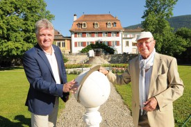 Dominique Willer, directeur de l’EMS Le Château de Corcelles, et l’ancien géomètre Ulrich Petereit, posent avec la réplique du globe gnomonique. © Michel Duperrex