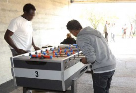 Le Soudanais Khalid (à g.) en pleine partie de baby foot. © Michel Duvoisin